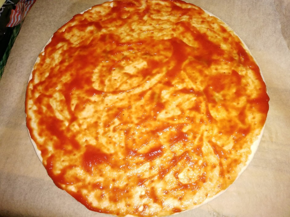 Picas pamatni nosmērē ar tomātu mērci.