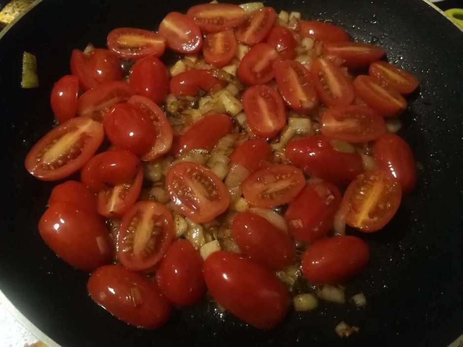 Kamēr garšaugi uz pannas, pārgriež uz pusēm ķiršu tomātiņus...